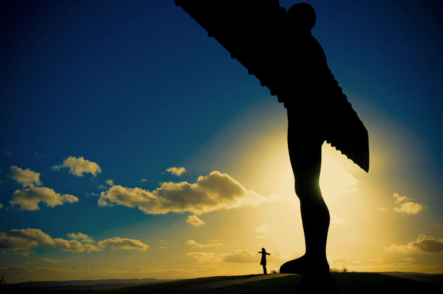 Angel of the North sculpture silhouetted against sunset sky
